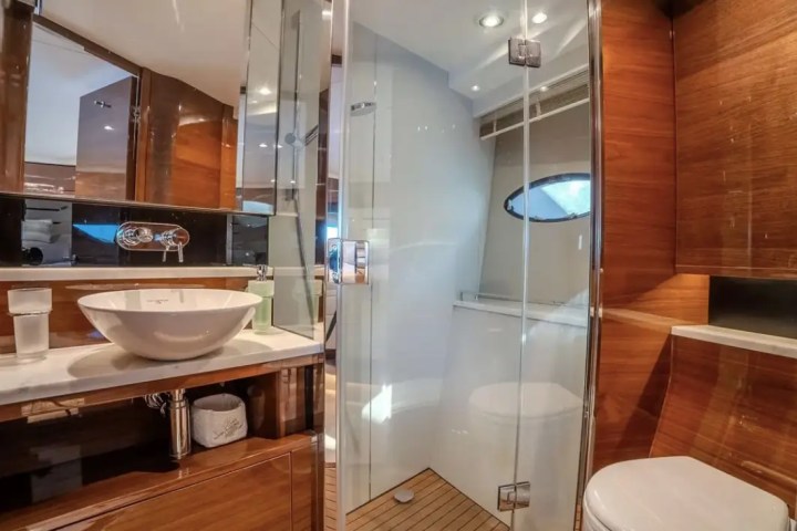 Modern bathroom with a vessel sink, glass shower, and wood accents.
