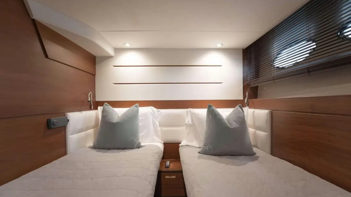 Modern cabin with two single beds, wooden walls, and soft lighting.