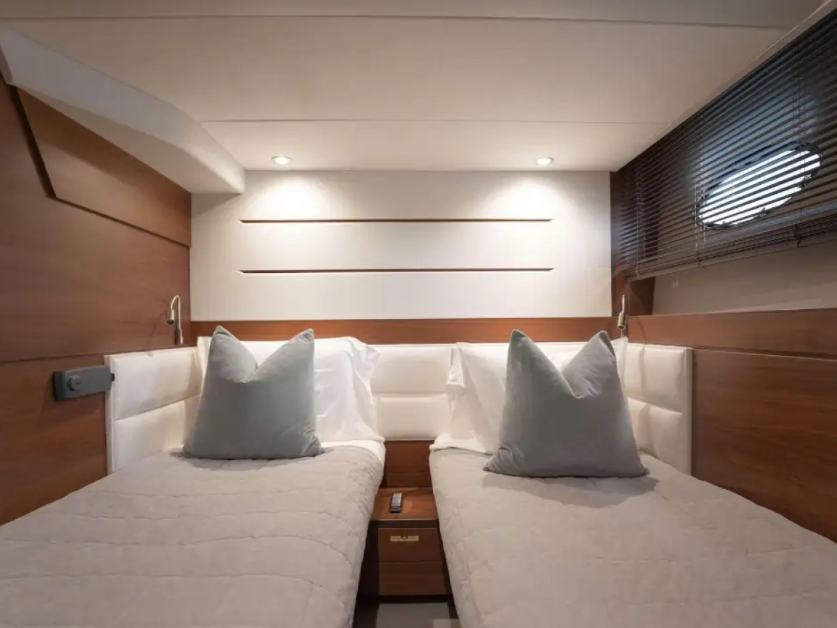 Modern cabin with two single beds, wooden walls, and soft lighting.