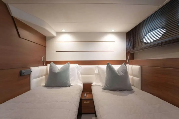 Modern cabin with two single beds, wooden walls, and soft lighting.