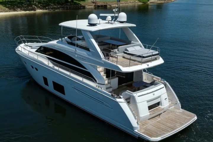 Large white yacht with multiple decks on a calm body of water.
