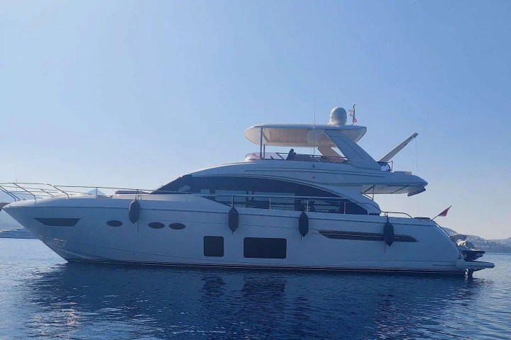 A luxury yacht on calm water under a clear blue sky.