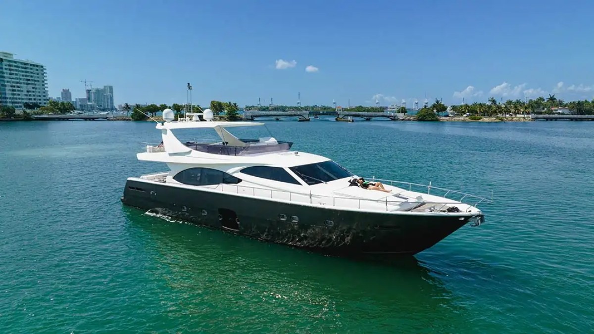 78' Ferretti yacht charter cruising Miami Beach in Biscayne Bay with guest relaxing on bow