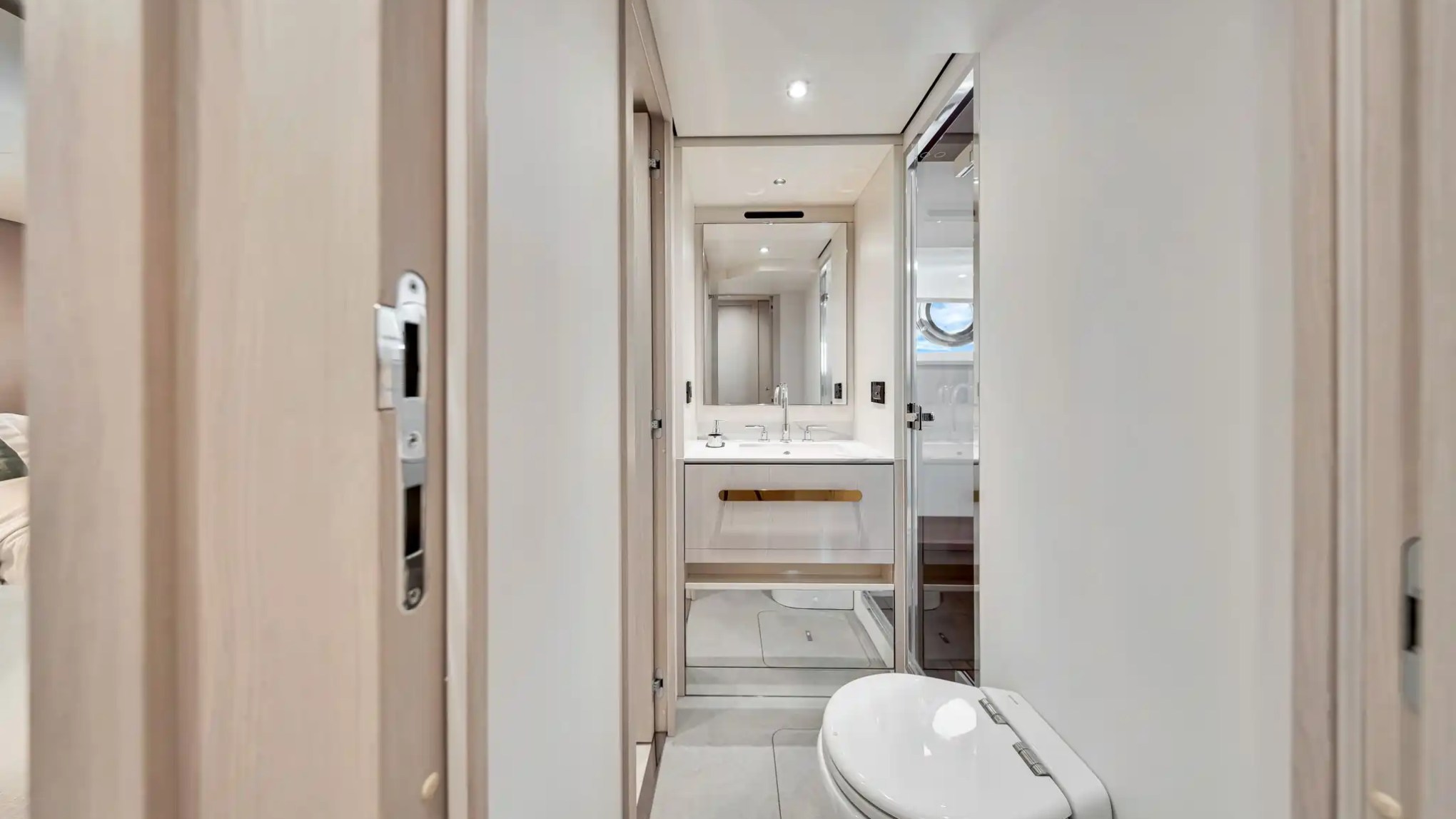 Modern bathroom with toilet, double sink, and large mirror.