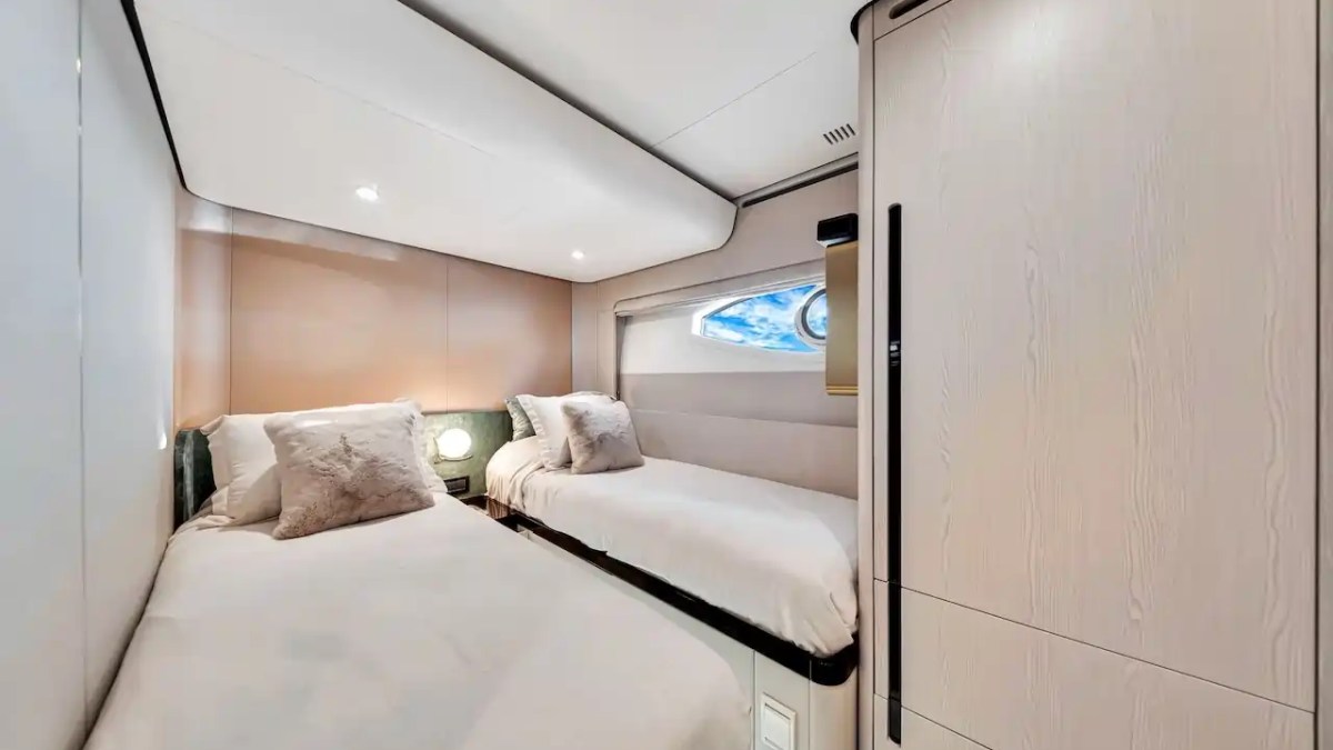 Cozy room with two single beds, a small window, and soft lighting.