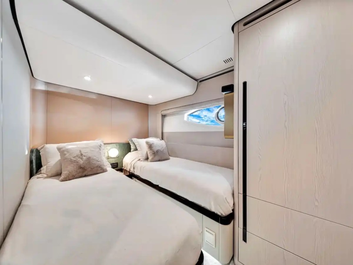 Cozy room with two single beds, a small window, and soft lighting.