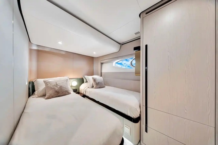 Cozy room with two single beds, a small window, and soft lighting.