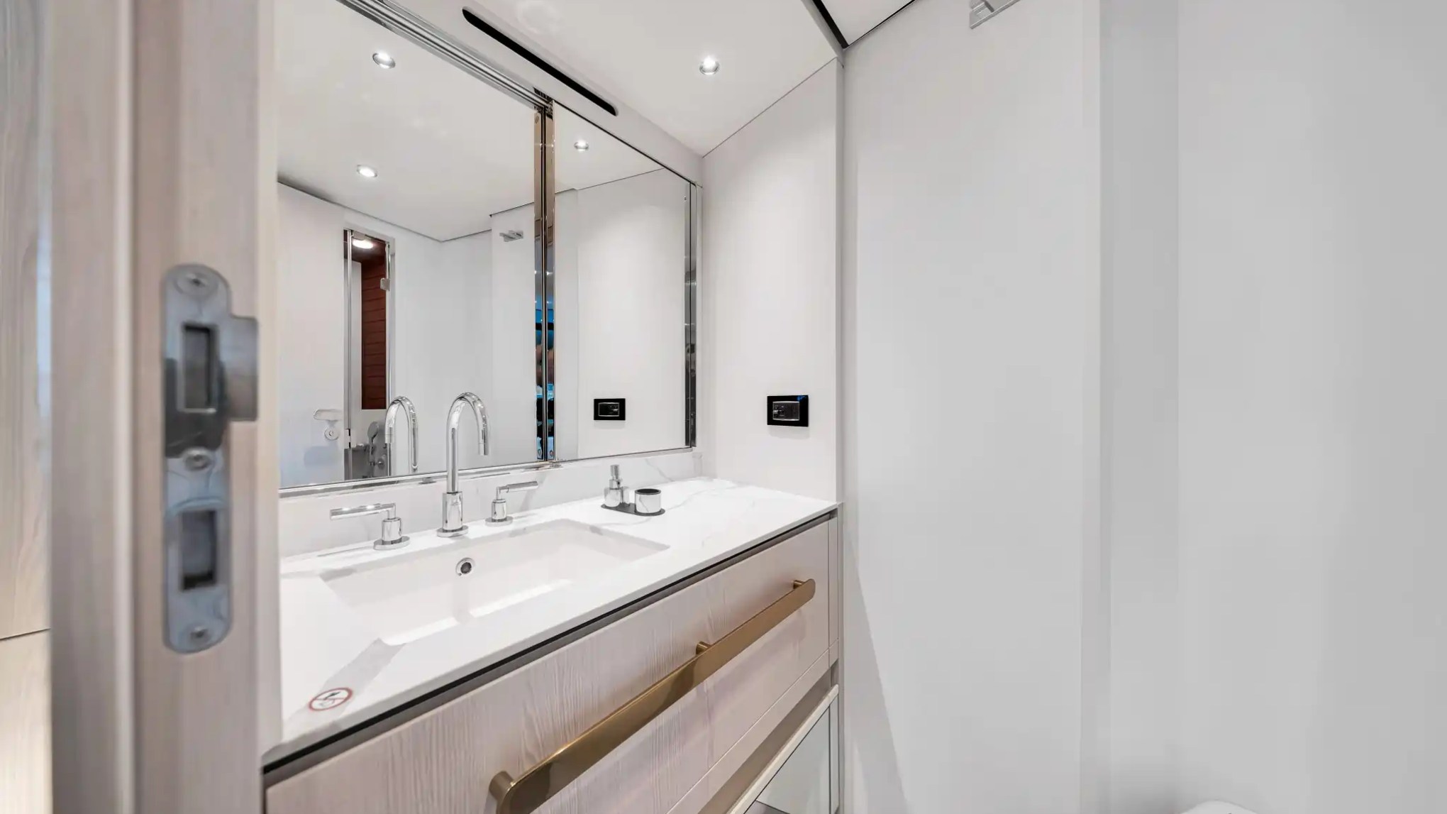 Modern bathroom with double sink, mirror, and minimalistic design.