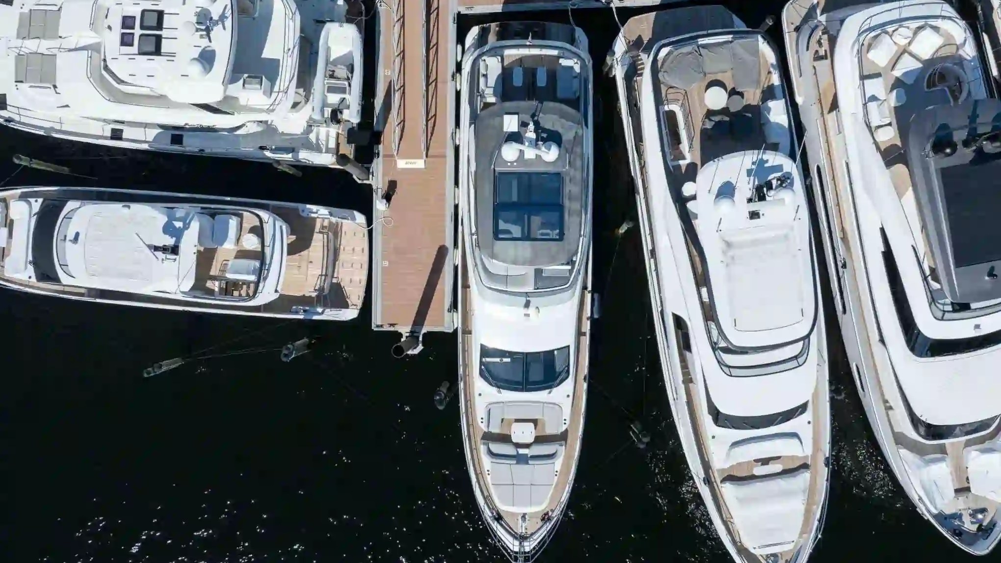 Top view of four yachts docked at a marina.