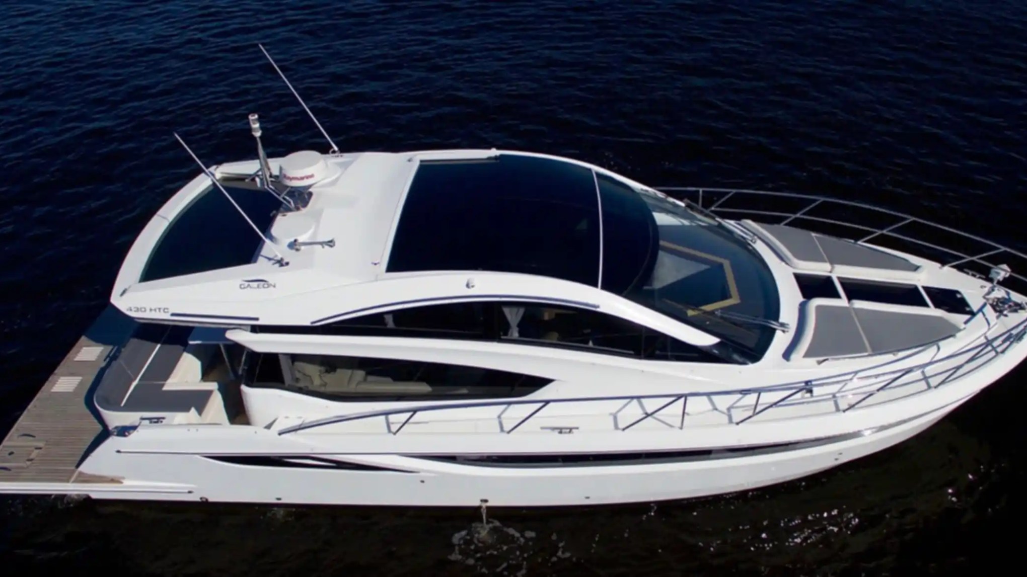 White yacht with sleek design floating on dark water.