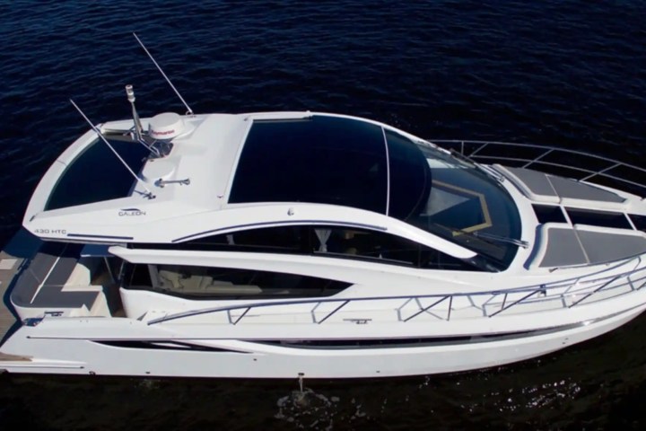 White yacht with sleek design floating on dark water.