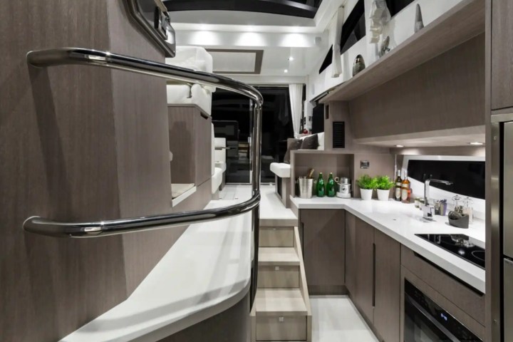 Modern yacht kitchen with sleek cabinets, stainless steel appliances, and a staircase.