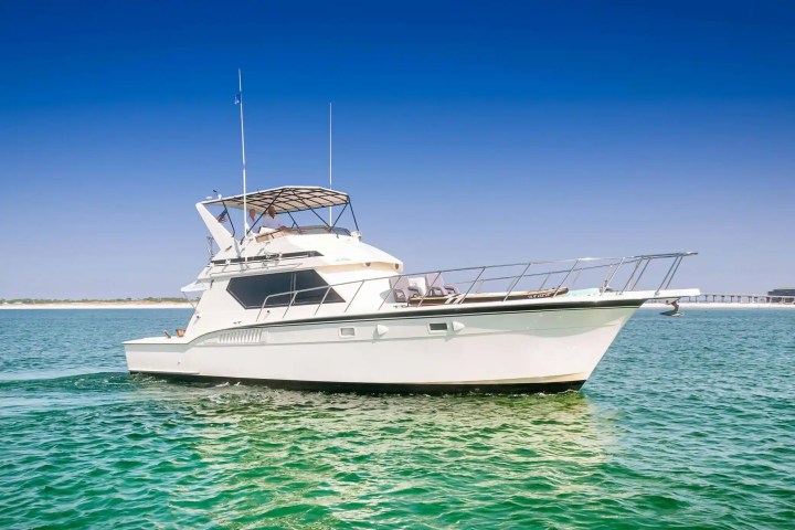 White motor yacht on calm sea under clear blue sky.