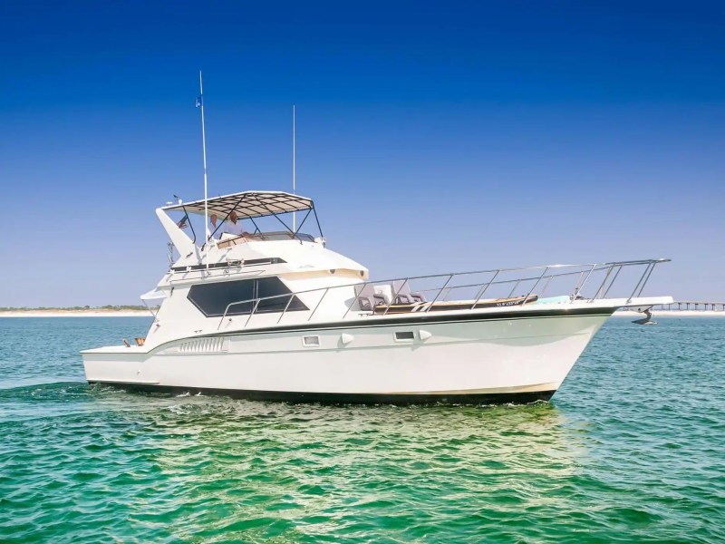 White motor yacht on calm sea under clear blue sky.