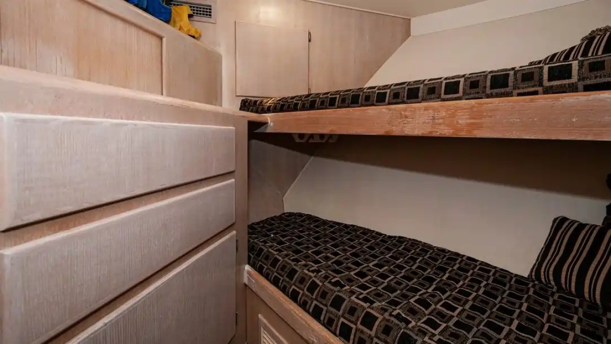 Small bedroom with two bunk beds and a cabinet on the left.