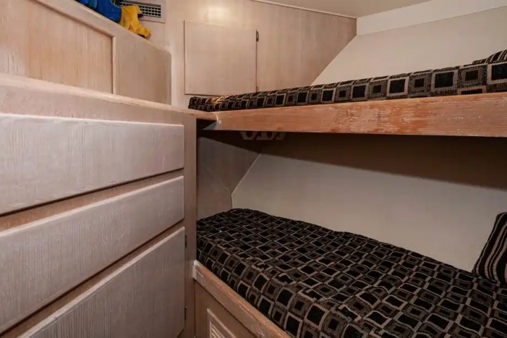 Small bedroom with two bunk beds and a cabinet on the left.
