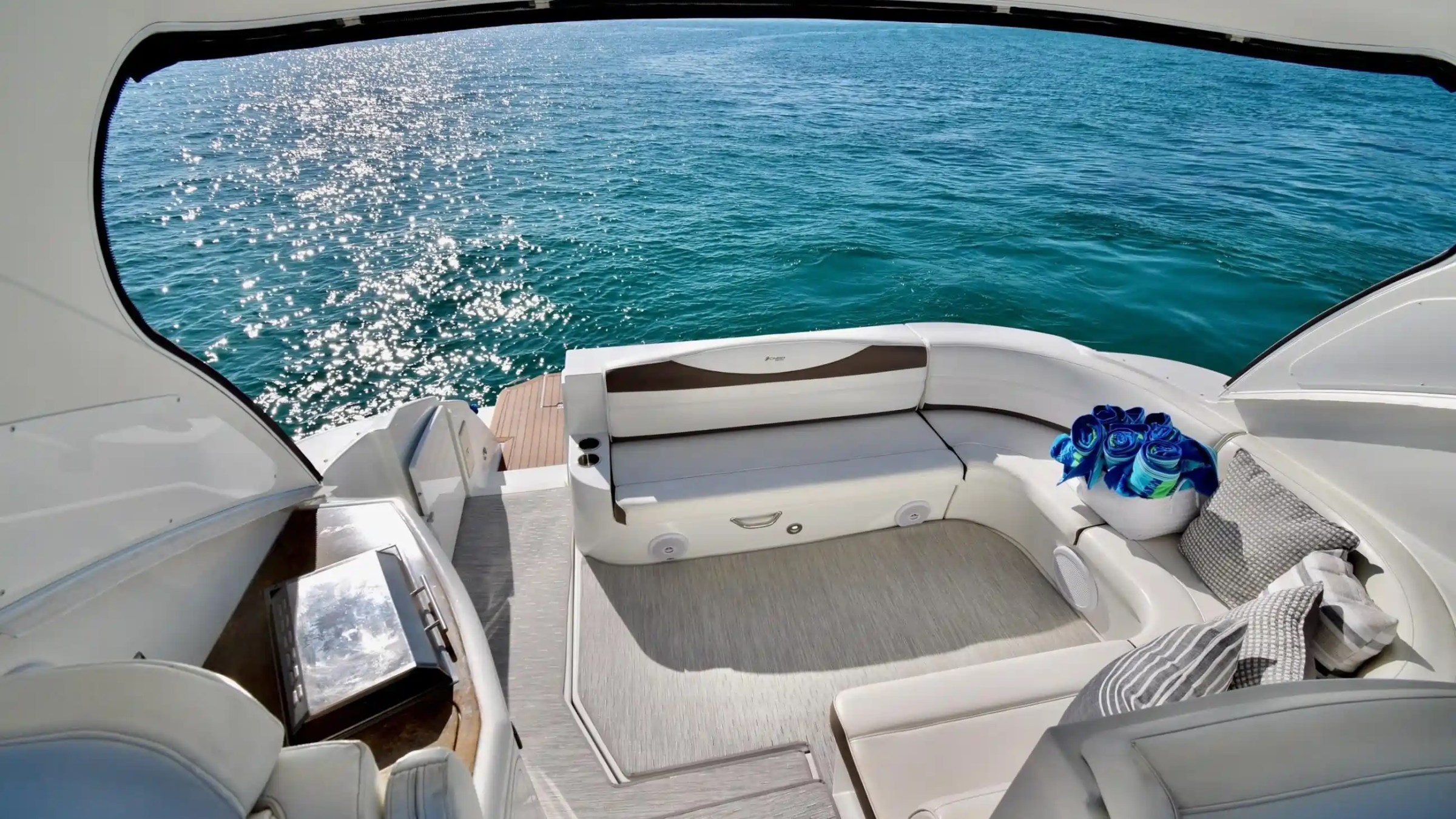 Luxurious boat interior with curved seats, table, and ocean view.