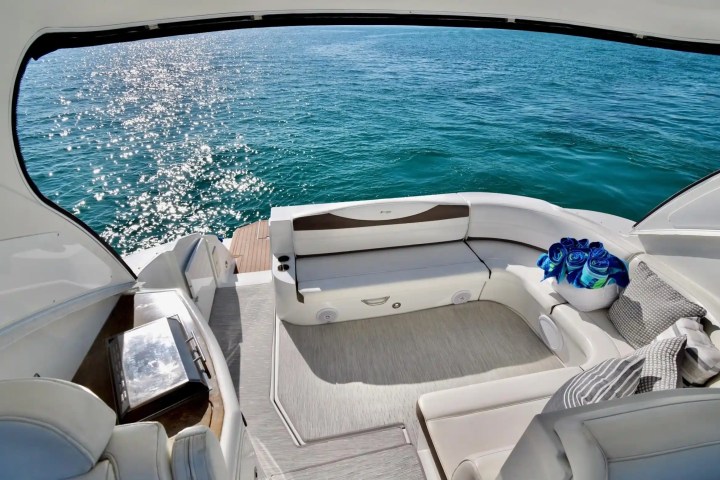Luxurious boat interior with curved seats, table, and ocean view.