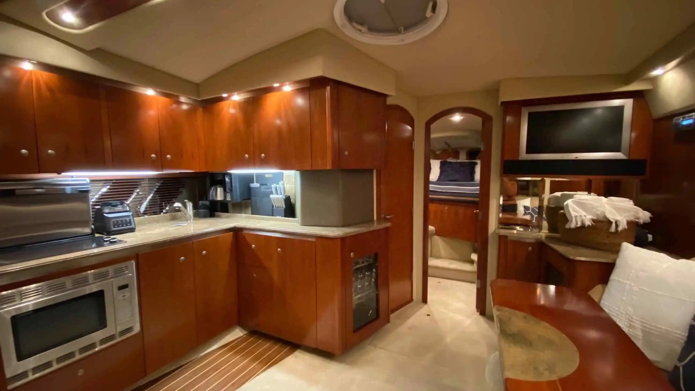 Luxurious yacht interior with kitchen, dining area, and bedroom.