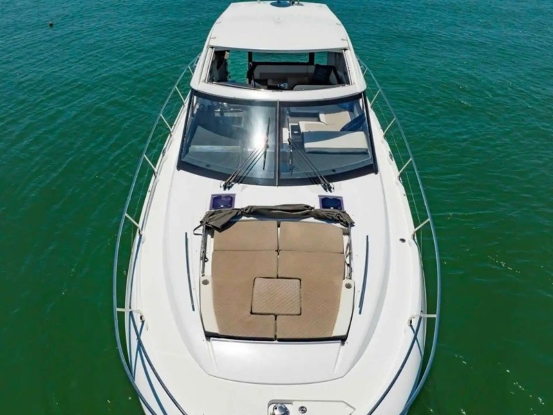 50' Jeanneau Leader 46 Yacht Charter aerial bow view showcasing expansive foredeck sun pad, sleek hardtop profile, and emerald waters off St. Petersburg Florida.