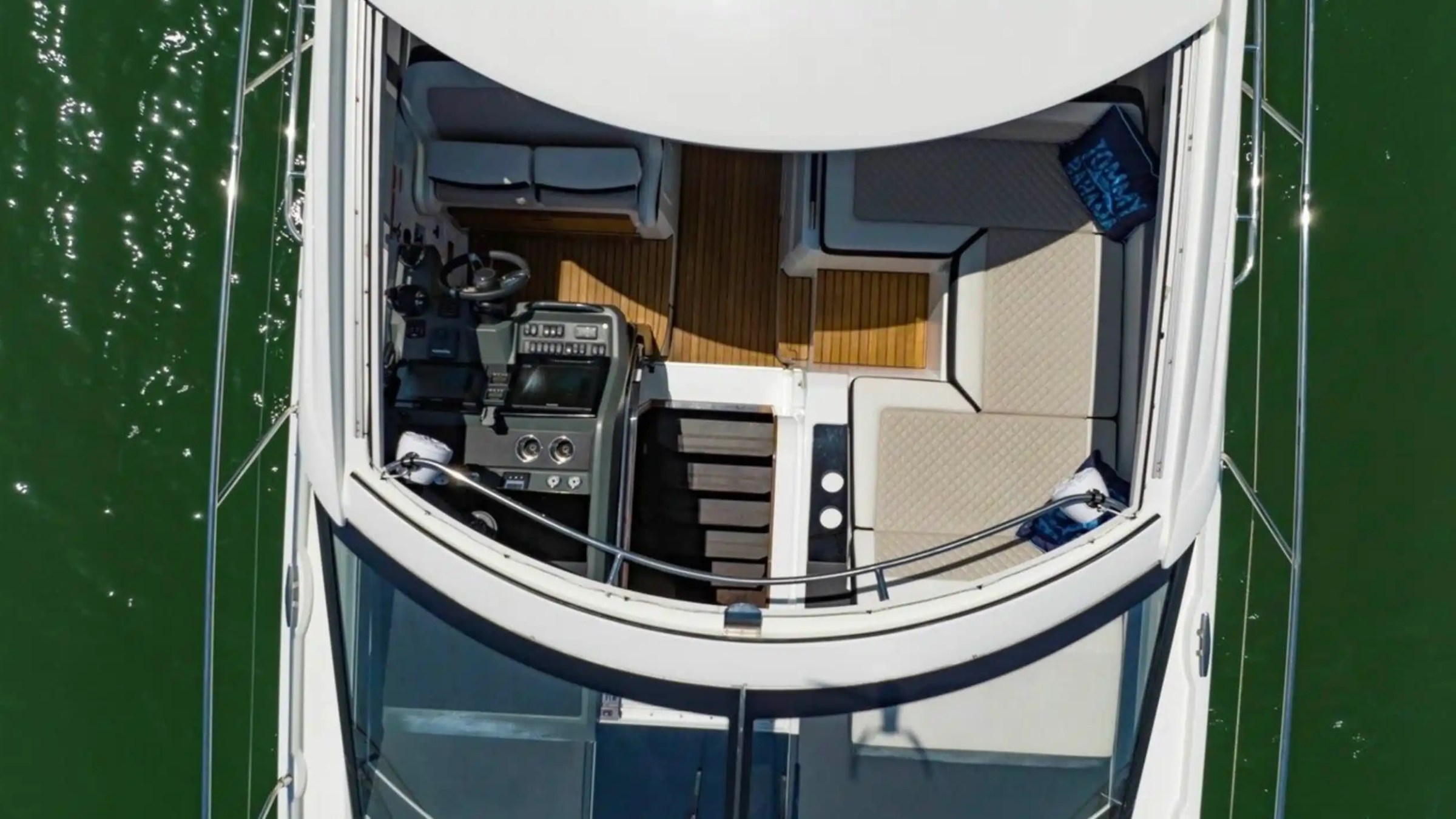Aerial view of a luxury yacht deck with seating and control panel.