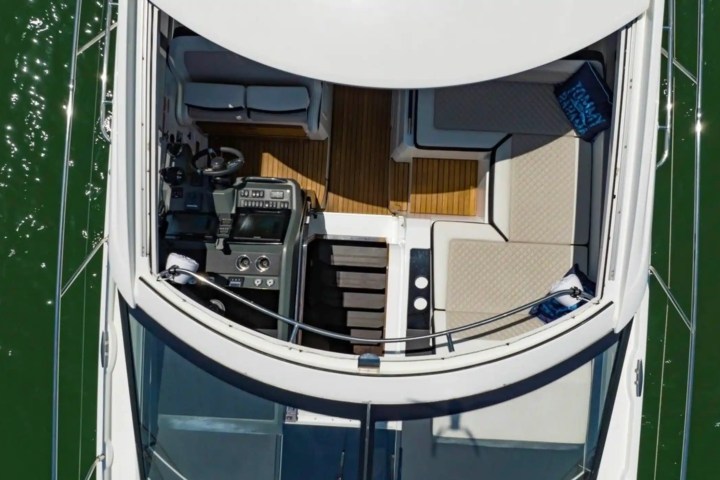 Aerial view of a luxury yacht deck with seating and control panel.