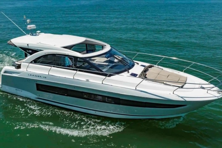 White motor yacht cruising on calm blue water.