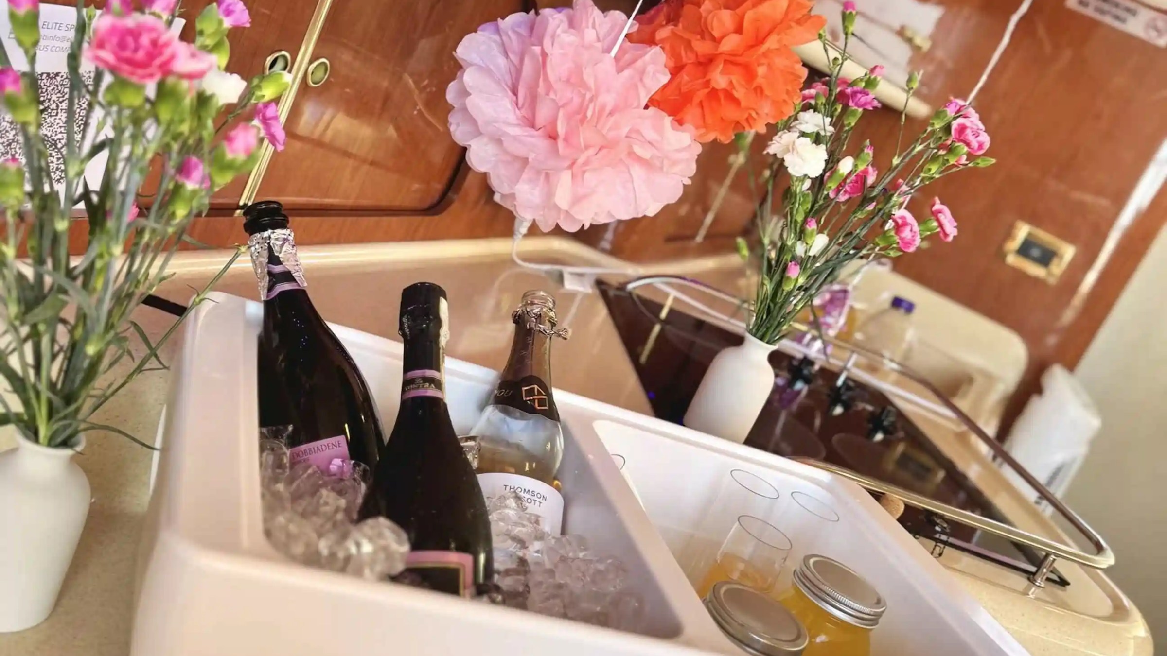 Ice bucket with champagne and flowers on a boat's kitchen counter.