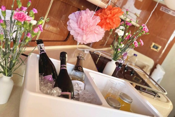 Ice bucket with champagne and flowers on a boat's kitchen counter.