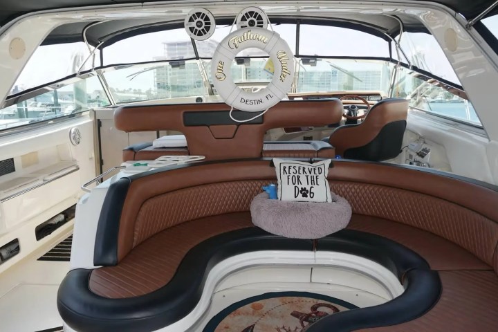 Interior of a luxury boat with brown seating and a life preserver labeled 'One Million Dollars.'