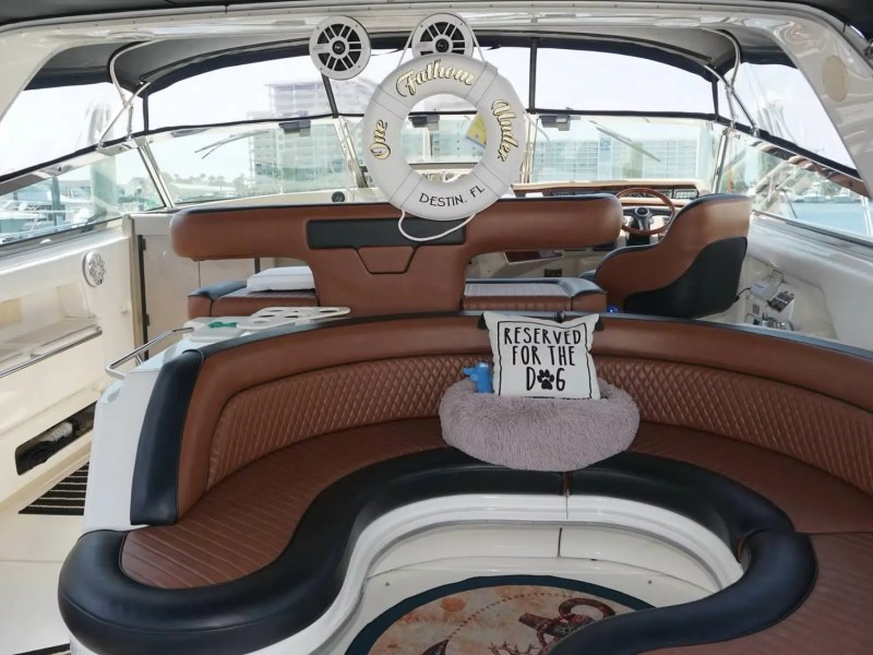 Interior of a luxury boat with brown seating and a life preserver labeled 'One Million Dollars.'