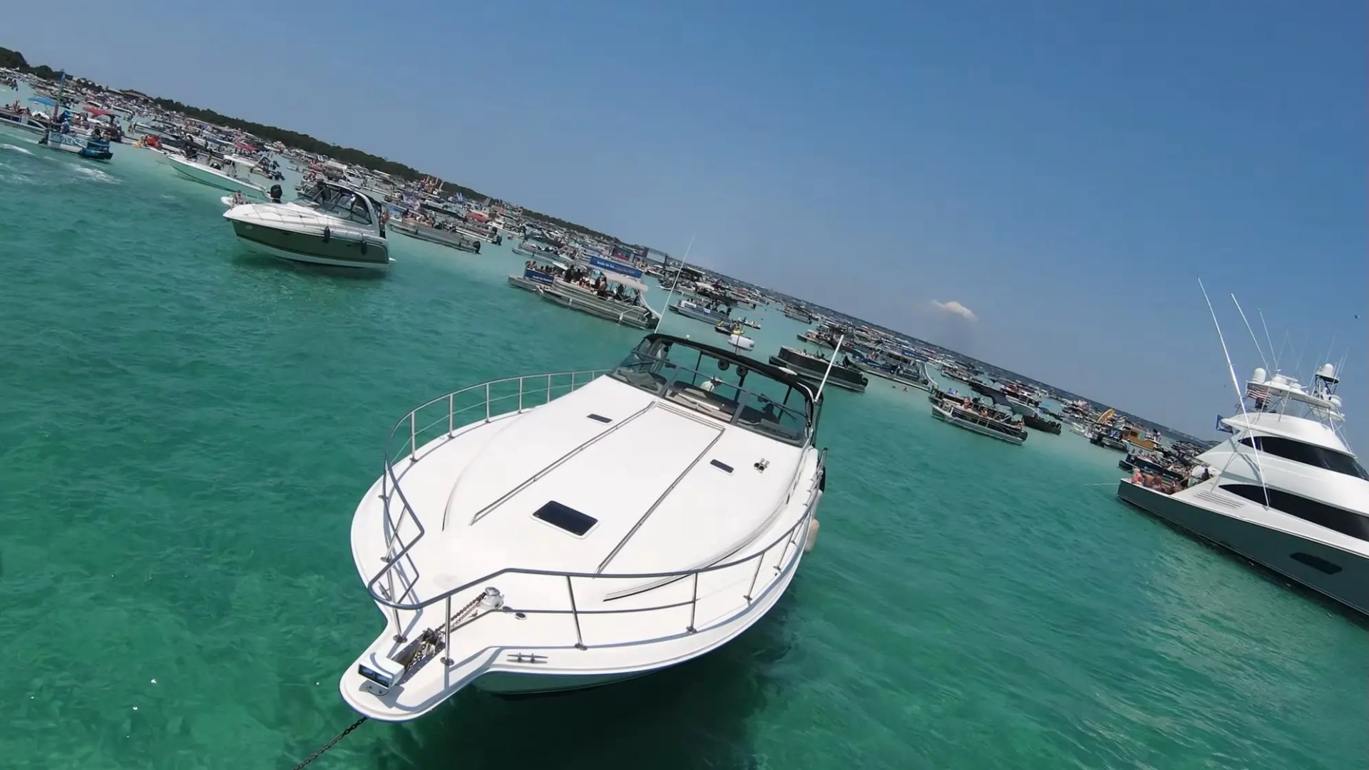 Boats gathered on turquoise water under a clear blue sky.