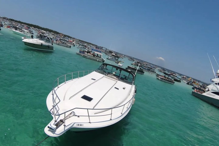 Boats gathered on turquoise water under a clear blue sky.