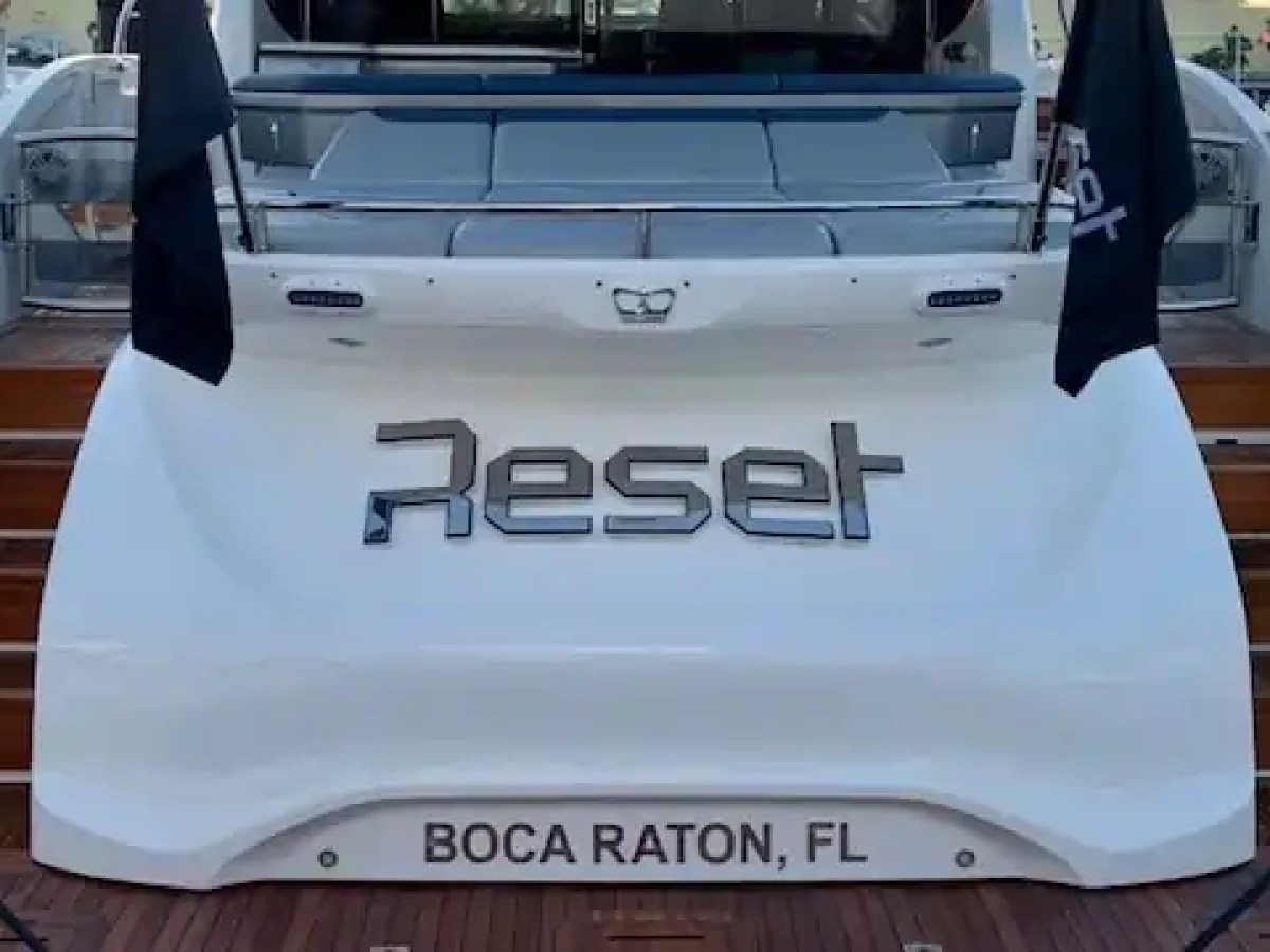 Rear view of yacht named 'Reset', docked with BOCA RATON, FL on stern.