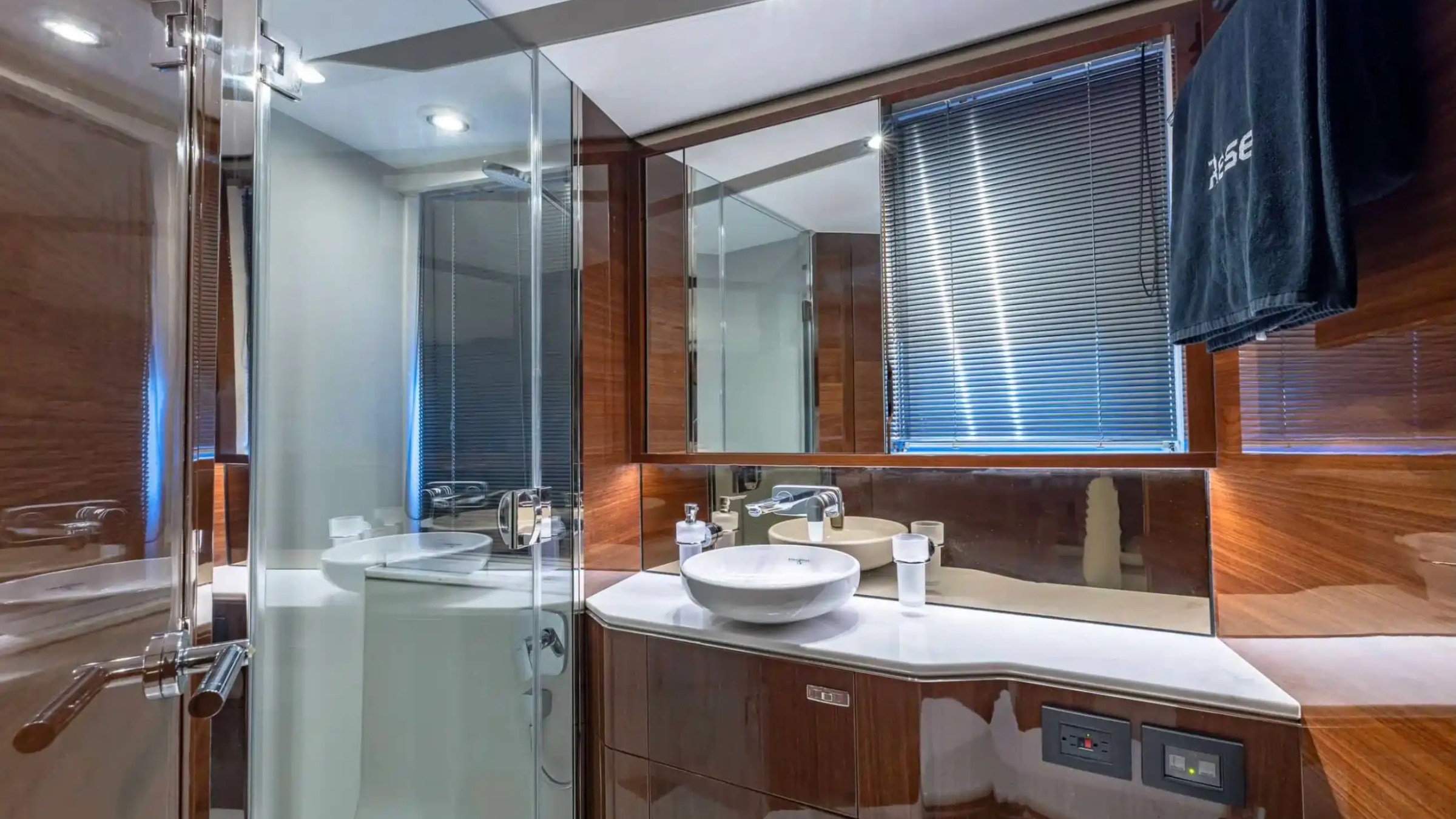 Luxurious bathroom with wooden accents, vessel sink, and glass shower.