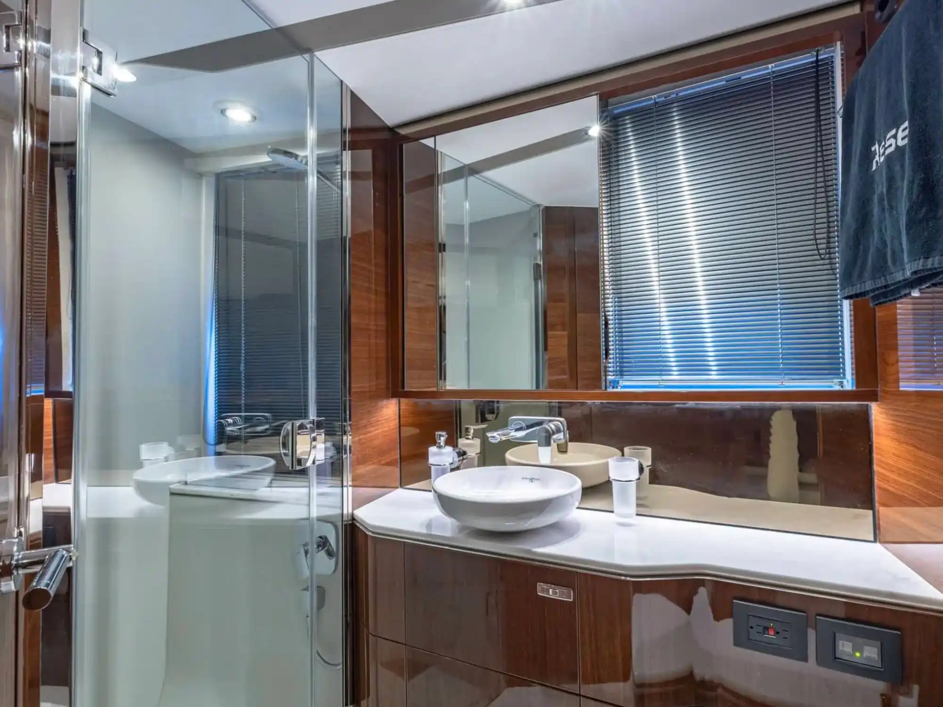 Luxurious bathroom with wooden accents, vessel sink, and glass shower.