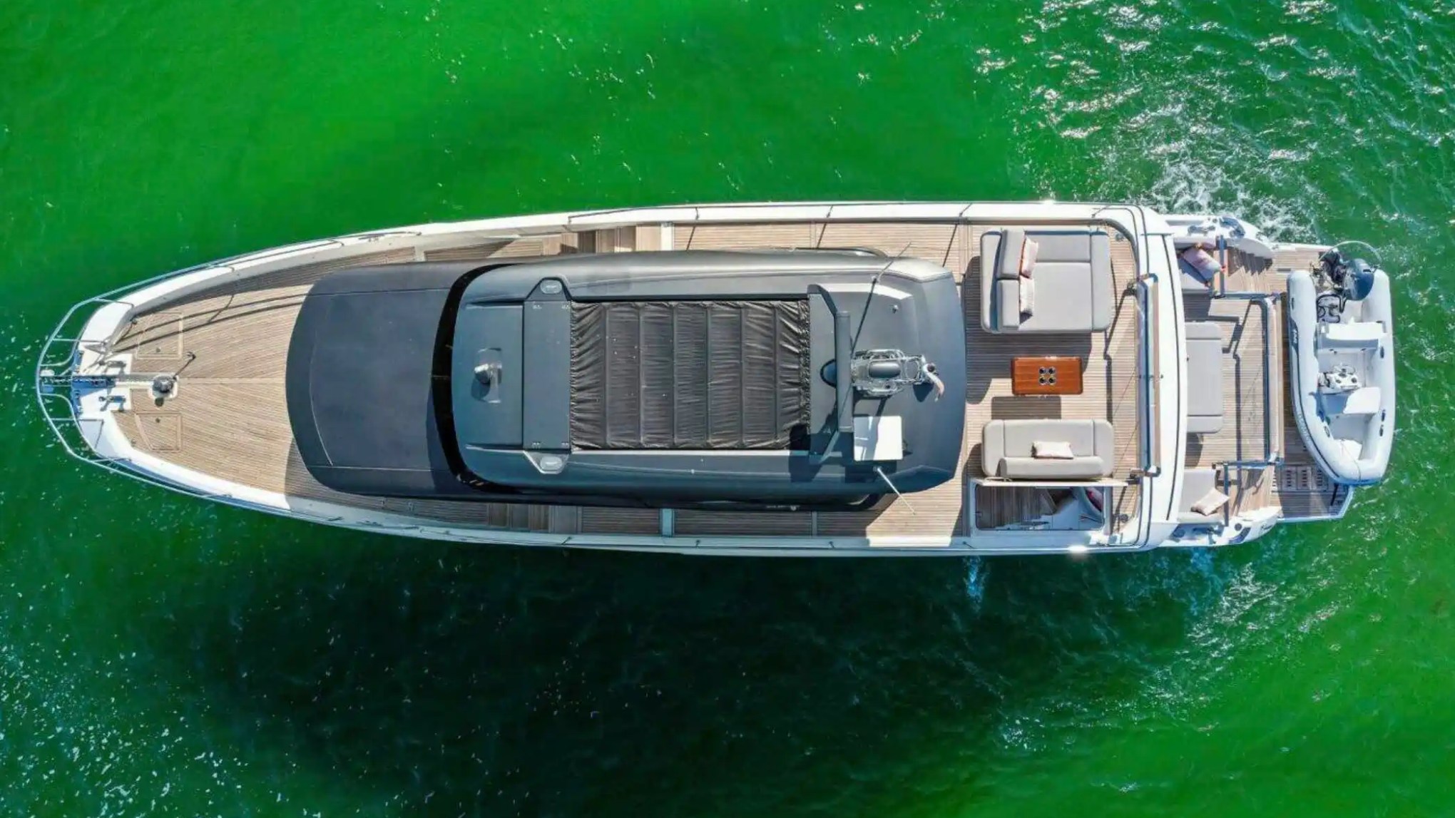 Aerial view of a luxury yacht sailing on green water.