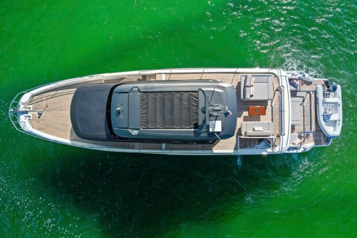 Aerial view of a luxury yacht sailing on green water.