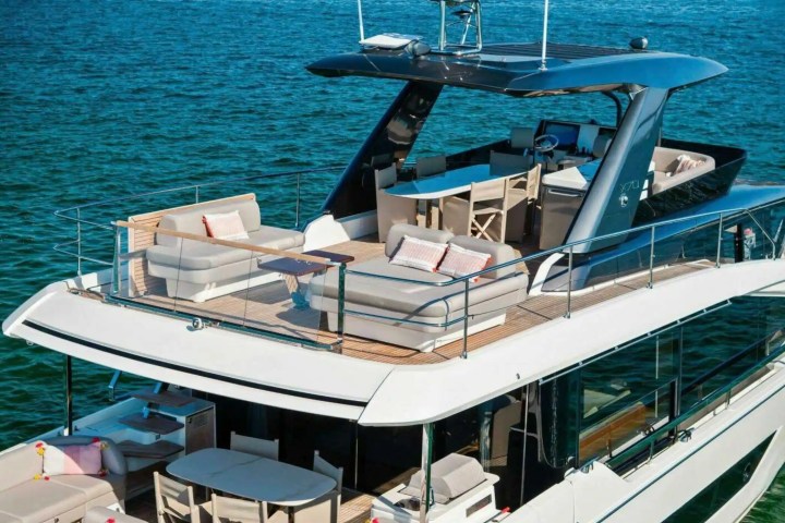 Luxury yacht with multiple decks and seating areas on blue water.