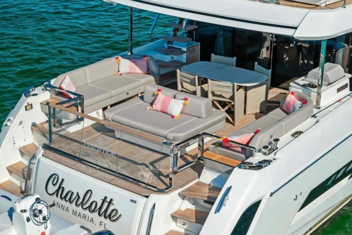 Luxurious yacht deck with outdoor seating, table, and cushions, labeled 'Charlotte, Anna Maria, FL'.