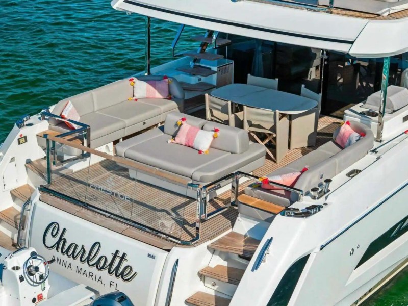 Luxurious yacht deck with outdoor seating, table, and cushions, labeled 'Charlotte, Anna Maria, FL'.