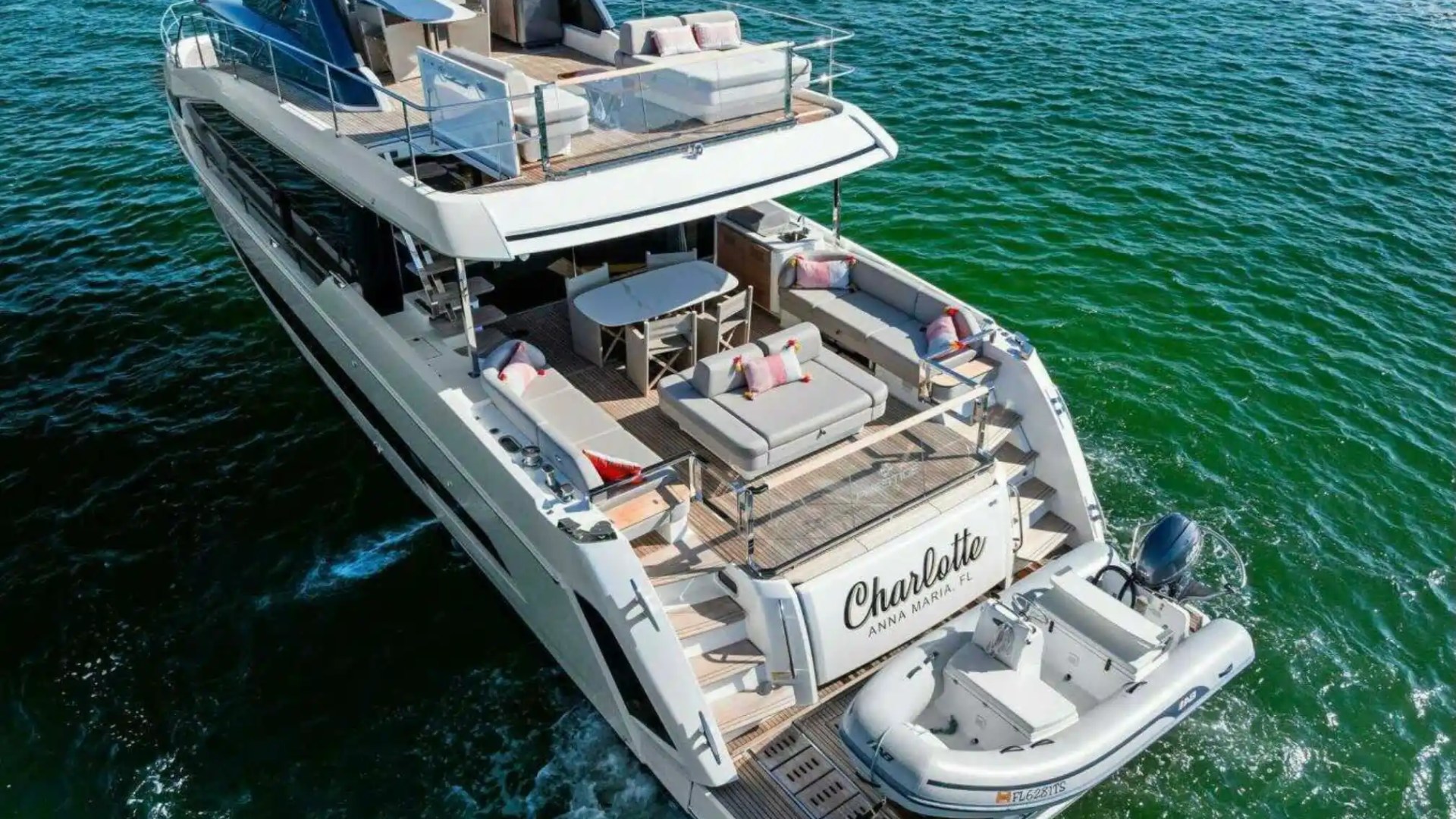 Luxurious yacht with multiple decks cruising through green ocean waters.