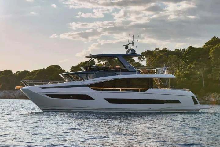 Large luxury yacht on calm water with trees in the background