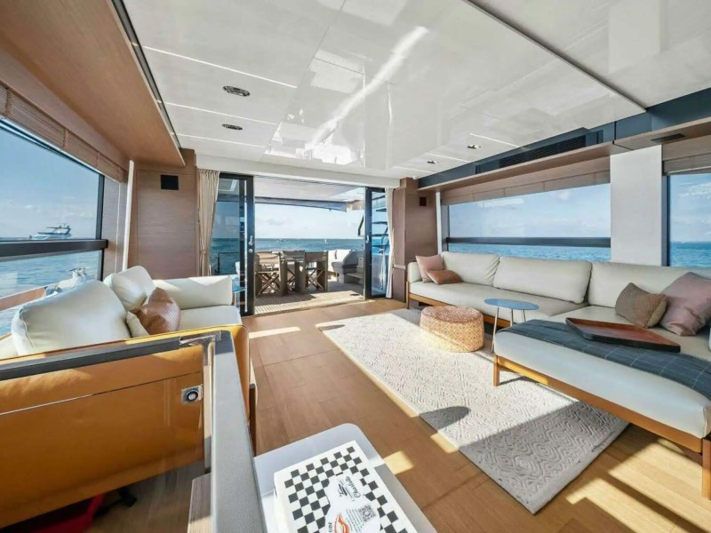 Spacious yacht interior with sofas, large windows, and ocean view.
