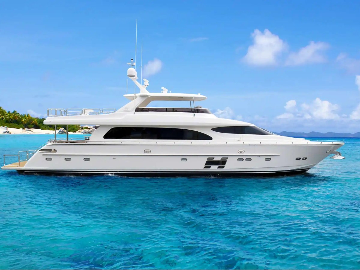 This 91 foot Horizon Yacht Charter is anchored in crystal-clear turquoise water with a full side profile view, expansive flybridge, and tropical island scenery near Jupiter and Palm Beach.