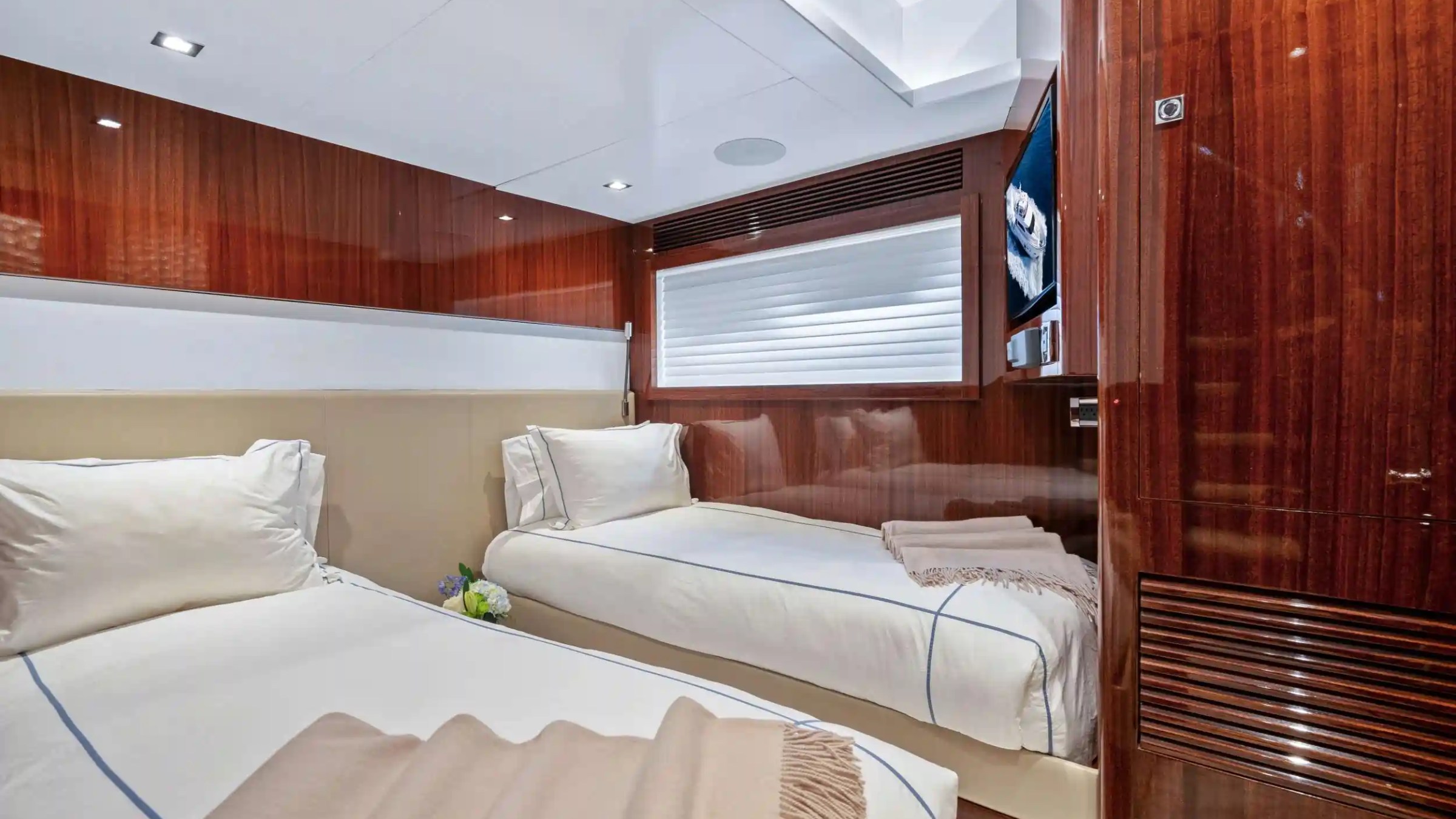 Luxurious cabin with two twin beds, wood paneling, and a window.