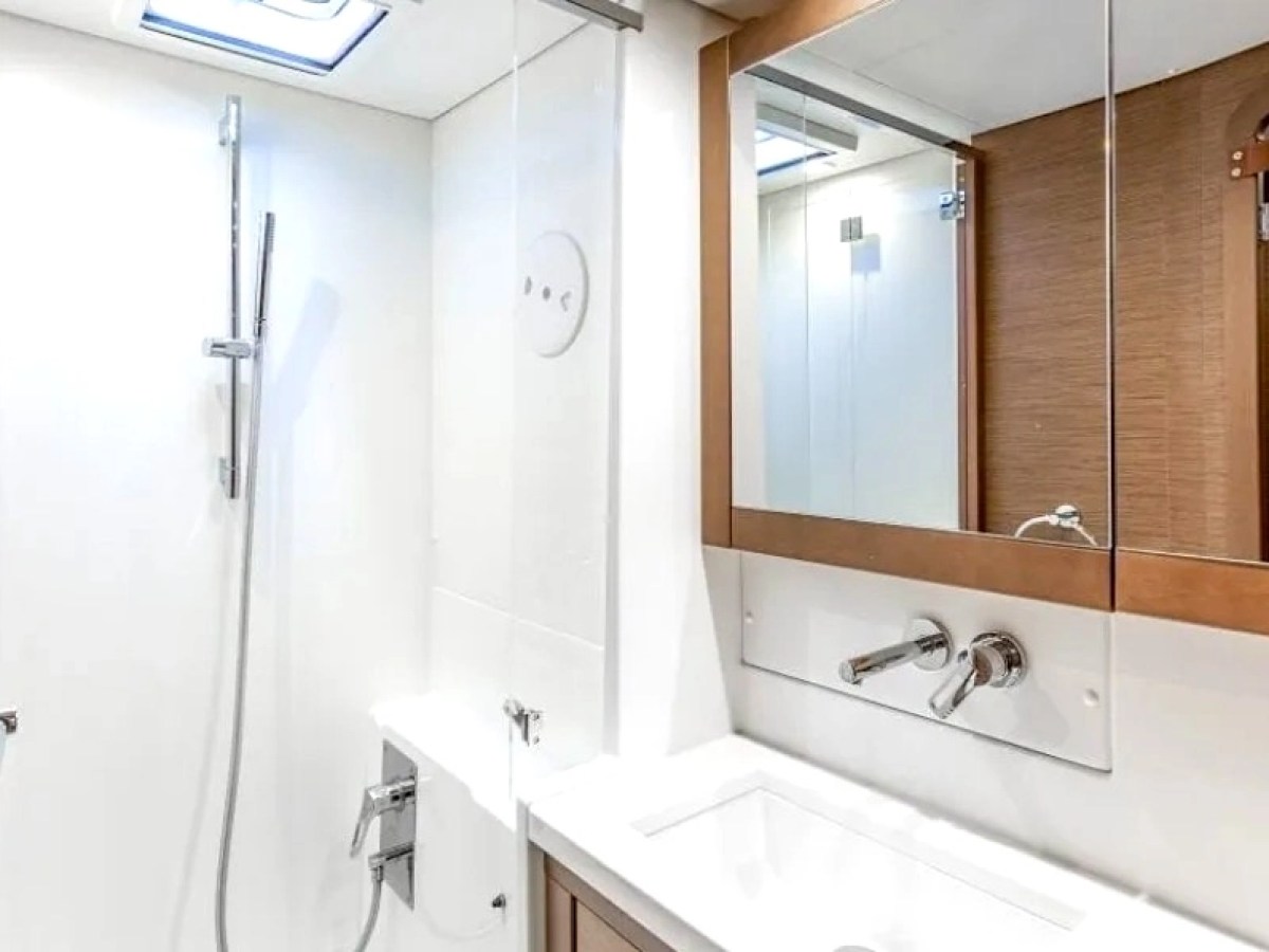 Modern bathroom with a shower, white surface, and mirrored cabinet over sink.