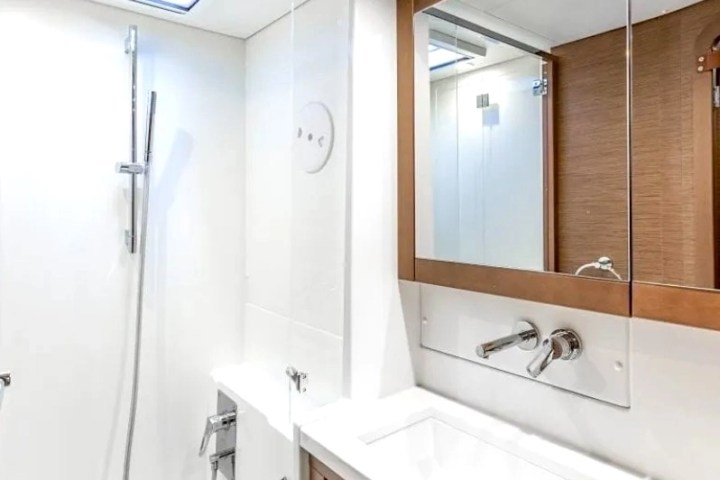Modern bathroom with a shower, white surface, and mirrored cabinet over sink.