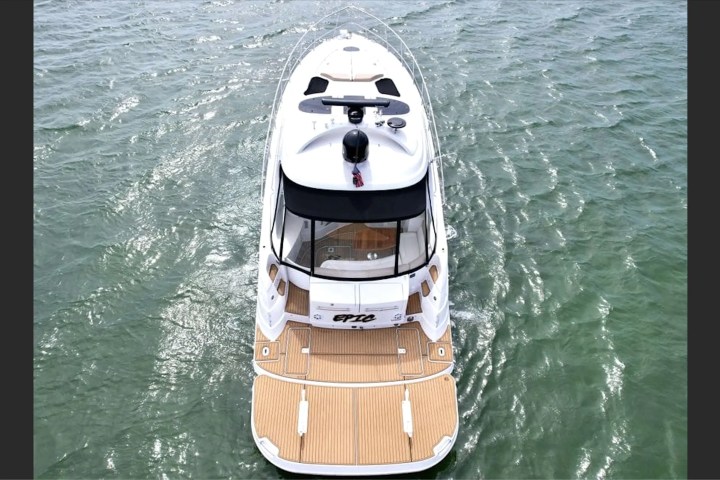 Top view of a white yacht on green ocean water.