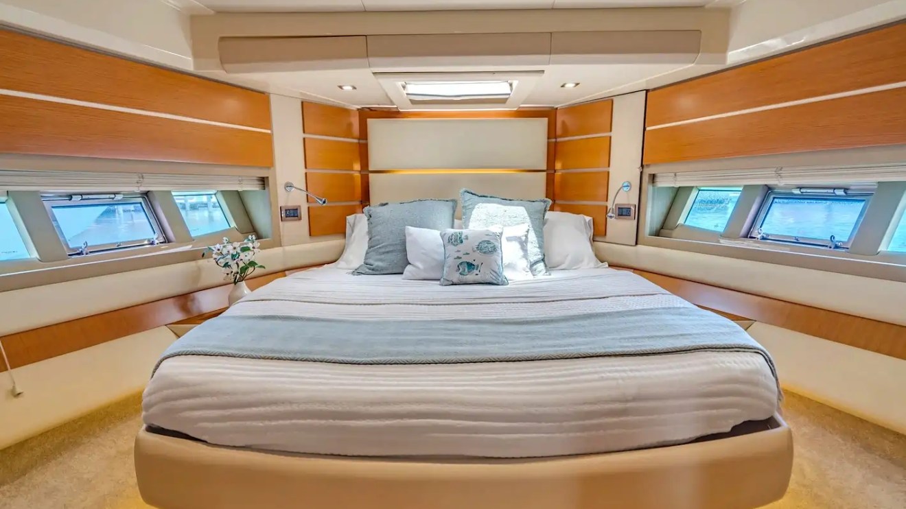 Luxurious yacht bedroom with large bed, pillows, and side windows.